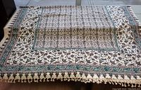 Full view of the rectangular Iranian block print tablecloth laid out, showing overall design and tasselled edges.