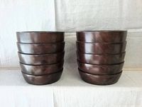 Stacked view showing the smooth polished dark wooden surface and horizontal grooves of the vases.