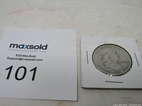1950 Franklin Half Dollar coin displayed in a cardboard coin holder alongside MaxSold auction lot number card