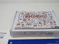 Full image of sealed 2020 Summary jigsaw puzzle box with colorful 2020 event icons and text on top face
