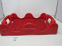 Image showing the red Coca Cola plastic crate from an angled top-down view highlighting handles and lattice base.