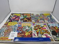 Overview of eight Ironman comic books laid out side by side with a ruler for scale.
