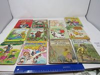 Overview of twelve used children's books, titles visible, colorful and worn covers
