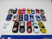 Front overview showing all twenty Nascar toy cars arranged in rows on a table.