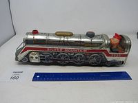 Full side view of the vintage Silver Mountain metal train showing the entire length including the figurine engineer and detailed lithographed design.