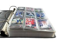 Side angle of black 3-ring binder with plastic sleeves filled with 1992 Leaf Set baseball cards showing multiple cards mostly of players in action poses.