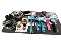 Photo showing all hair brushes, headbands, and hair clips laid out on a table, capturing variety and quantity of items in the lot.