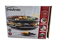 Box showing the Trudeau Oval Party Grill Set with a photo of the cooking surface grilled food and raclette pans, indicating 18 pieces included.