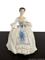 Front view of the Royal Doulton Kelly figurine showcasing the blue floral decoration and woman's face.