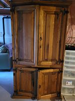 Front view of pine hutch with two upper and two lower wooden doors, showing natural wood grain and keyhole hardware.