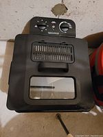 Black deep fryer with front window and two control knobs on top