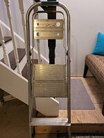 Aluminum hand truck with two platforms shown folded with visible wear marks.