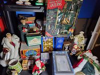 Wide shot showing the full collection of Christmas figurines, decorations, boxed music lanterns, and assorted ornaments on display.