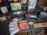 Wide view of lot including radios, timer, accessories, and wooden box on table