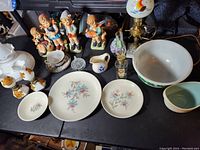 Photo shows all items including lamps, figurines, ceramic dishes, glassware arranged on black surface.