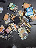 Pile of assorted Magic the Gathering cards showing backs and fronts in a scattered arrangement.