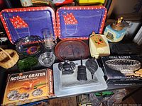 Overview of lot with trays, bowls, kitchen tools, and boxes