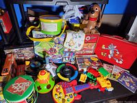 Photo showing the assortment of toys including musical toys, Beyblade box, plush dog, Simon game, and Tom and Jerry collectible bag.