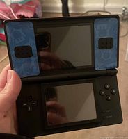 Front view of Nintendo DS open, showing dual screens and control buttons