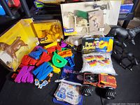 Various Breyer horse models, colorful plastic letters, small character toys, toy truck, and pea lights seen together