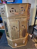 Front and side view of the vintage metal noodle display case featuring ventilation cut-outs and double doors with a small latch.