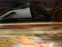 Photo showing a side view of multiple sealed magazines stacked, titles showing 'Entertainment for Men' and 'Playboy'