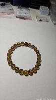 Photo of the AAA Baltic blue amber beaded bracelet laid flat on a white surface, showing uniform round amber beads.