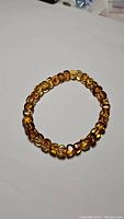 Top view of amber bead bracelet showing multiple small polished beads in honey to yellow shades.