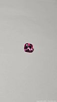 Single natural hot pink cushion cut topaz gemstone on white background