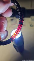 Close-up image showing the deep red translucent beads illuminated by light revealing their amber characteristics.