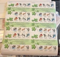 Full view of multiple sheets of 13-cent US philatelic stamps with animal motifs and Canadian International Philatelic Exhibition branding, arranged in rows with a maple leaf graphic.