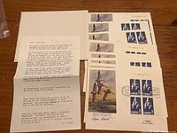 Photo showing all 10 covers in a stack with visible signatures and attached dealer paperwork.