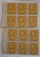 Photo of two plates each containing six 1 cent King George V orange Canada postage stamps from 1929. One plate shows tabs that are intact and ungummed.