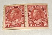 Front view of two connected 2 cent Canadian postage stamps in pale rose color with profile of King George V.
