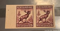 Front view of the pair of imperforate stamps showing the caribou design and denomination.