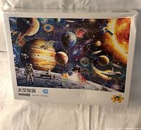 Sealed 1000-piece jigsaw puzzle box showing space-themed image including planets, astronauts, and spacecraft.