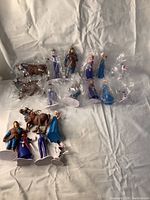 Group photo showing all Frozen character figurines, some loose and some wrapped in plastic.