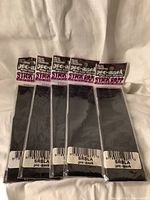 Front view of five sealed black Pro-Mark Stick Rapp drum stick wraps packaged individually and laid out side-by-side.