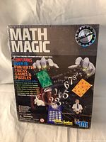 Front of sealed Math Magic kit box with title, key visuals including magician's hands, rabbit, calculator, and numbers