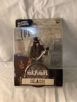 Front view of sealed Slash figurine in original Super Stars packaging showing figurine and branded cardboard backing.