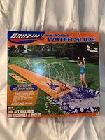 Front of sealed box showing Banzai Soak 'N Splash Water Slide with images of children playing on the slide and splash pool.