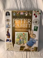 Front view of the hardcover book titled 'The Ultimate Peter Rabbit: A Visual Guide to the World of Beatrix Potter' with various illustrations on the cover.