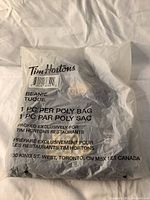 Sealed clear poly bag containing one winter beanie. Bag marked with Tim Hortons branding and product information.