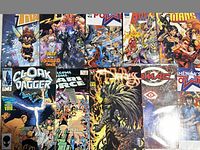 Photo showing an assortment of eleven comic books including Teen Titans, Cloak and Dagger #2, Marie comic, Darkness, Space Ghost, Huntress and more with detailed colorful superhero art covers.