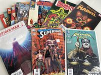 Photo shows nine assorted comic books from DC and Marvel including Superman, Spiderman, Batman, Micronauts, Dreadstar, and a Marvel cover with Mr. Darcy variant.