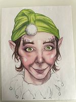Close-up photo of a colored pencil and ink drawing of an elf with a green hat and detailed facial features.