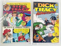 Two vintage Dick Tracy comic books in protective sleeves. One titled 'The Birth of Sparkle Plenty!' part of the Reuben Award Winner Series, the other titled 'Dick Tracy Adventures' with an action scene on the cover.