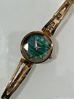 Front angled full view of the watch showing gold-tone metal case and linked bracelet with green faceted dial displaying brand name Read and roman numerals.