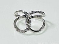 Photo showing the front and top view of the sterling silver double loop ring with one loop covered in stones and 'NVC 925' markings inside the band.