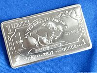 Front side of titanium bullion bar showing United States of America, 1 titanium, bullion, one troy ounce .999 fine, buffalo image, and serial number.